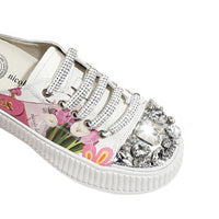 A CLOSER LOOK TO THE FRONT OF OUR VIOLET BLOSSOM MULE PLATFORM SNEAKERS. WHITE COLOR WITH WHITE LACES EMBELLISHED WITH RHINESTONES .