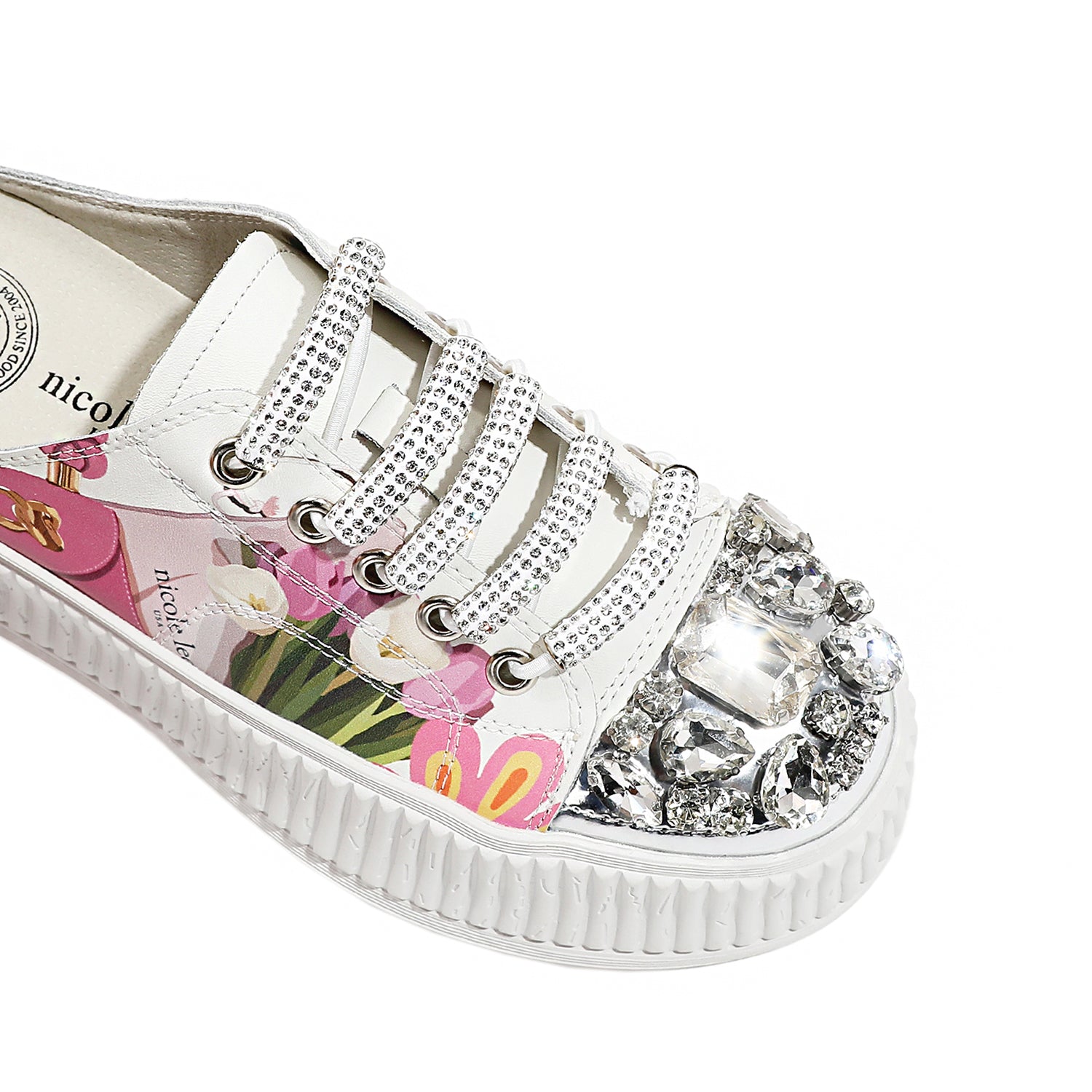 A CLOSER LOOK TO THE FRONT OF OUR VIOLET BLOSSOM MULE PLATFORM SNEAKERS. WHITE COLOR WITH WHITE LACES EMBELLISHED WITH RHINESTONES .