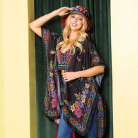 Woman in a colorful crop top and blue jeans stylishly posing and showing off her Kimono Nicole Lee in Alma de Colores design.