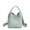Introducing Juni from Nodu Nadu by Nicole Lee, a versatile and slouchy chic handbag with a removable pouch inside. Crafted in braided vegan leather with an optional, adjustable chevron striped shoulder strap for varied carrying options so you can wear it across the body or by the top handle for a sleek look. Pictured in a pastel, dusty blue shade with a tonal striped shoulder strap.