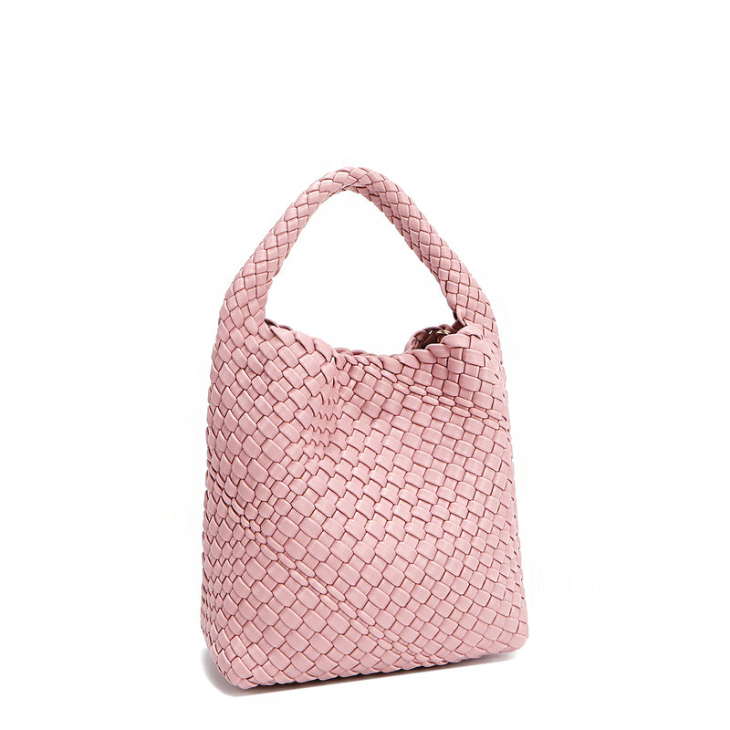 Back angle of Juni handbag crafted in braided vegan leather in pastel, dusty pink with a top handle (5" drop) and open slip compartment secured with a magnetic snap closure. Slouchy, relaxed silhouette offers a chic and laid-back yet refined look.