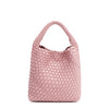 Back of Juni handbag crafted in braided vegan leather in pastel, dusty pink with a top handle (5" drop) and open slip compartment secured with a magnetic snap closure. Slouchy, relaxed silhouette offers a chic and laid-back yet refined look.