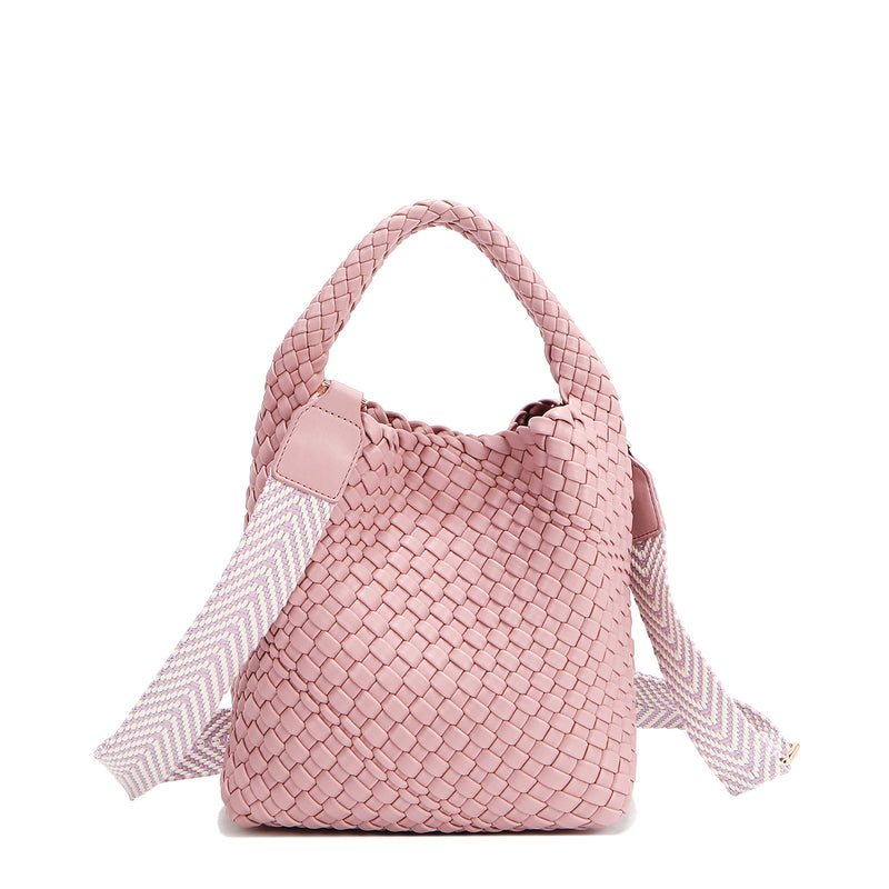 Introducing Juni from Nodu Nadu by Nicole Lee, a versatile and slouchy chic handbag with a removable pouch inside. Crafted in braided vegan leather with an optional, adjustable chevron striped shoulder strap for varied carrying options so you can wear it across the body or by the top handle for a sleek look. Pictured in a pastel, dusty pink shade with a tonal striped shoulder strap. Feminine, sweet, and oh-so stylish!