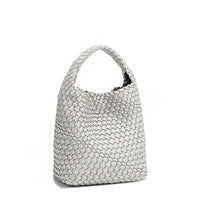 Back angle of Juni handbag crafted in braided vegan leather in metallic silver with a top handle (5" drop) and open slip compartment secured with a magnetic snap closure. Slouchy, relaxed silhouette offers a chic and laid-back yet refined look.