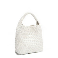 Back angle of Juni handbag crafted in braided vegan leather in classic, timeless white with a top handle (5" drop) and open slip compartment secured with a magnetic snap closure. Slouchy, relaxed silhouette offers a chic and laid-back yet refined look.