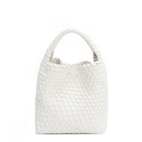 Juni handbag crafted in braided vegan leather in classic, timeless white with a top handle (5" drop) and open slip compartment secured with a magnetic snap closure. Slouchy, relaxed silhouette offers a chic and laid-back yet refined look.