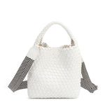 Introducing Juni from Nodu Nadu by Nicole Lee, a versatile and slouchy chic handbag with a removable pouch inside. Crafted in braided vegan leather with an optional, adjustable chevron striped shoulder strap for varied carrying options so you can wear it across the body or by the top handle for a sleek look. Pictured in a classic, timeless white shade with a black and white tonal striped shoulder strap.