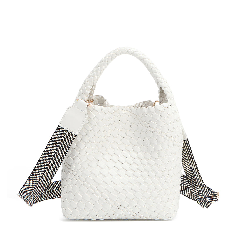 Introducing Juni from Nodu Nadu by Nicole Lee, a versatile and slouchy chic handbag with a removable pouch inside. Crafted in braided vegan leather with an optional, adjustable chevron striped shoulder strap for varied carrying options so you can wear it across the body or by the top handle for a sleek look. Pictured in a classic, timeless white shade with a black and white tonal striped shoulder strap.