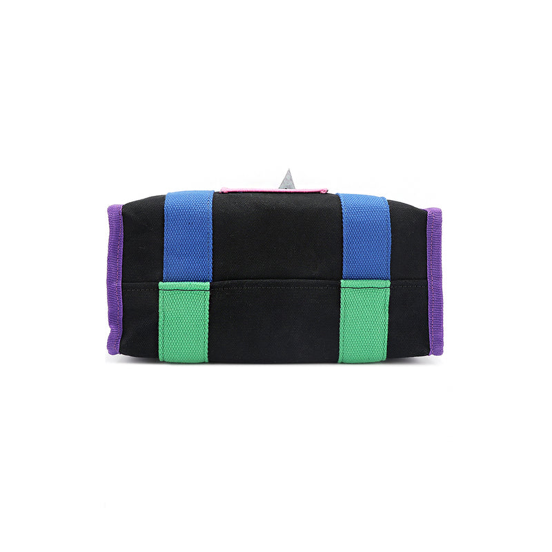 Structured, rectangular base of the Rowan handbag in black by Nodu Nadu. Royal purple trim is accented by the vivid blue and green straps that join together for a mix and match color story. 