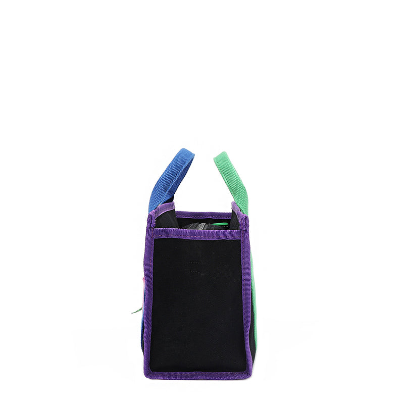 Structured and rectangular side silhouette of the Rowan bag by Nodu Nadu in the color black. Features vibrant purple, vivid green, and electric blue trim and strap accents for a pop of color against the complimentary and timeless black colorway. A recessed zip top closure keeps your possessions secure. 