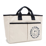 Your daily dose of positivity—now in bag form! With sleek trim details and a feel-good message, this everyday tote is here to remind you that yes, today (and every day) is a good one. Designed for both style and function, it features plenty of compartments inside like 2 front slip pockets. Pictured in classic, canvas-colored beige front angle view for a timeless statement that compliments any look from day to night! 