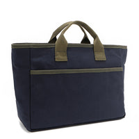 Back angle of the Emery Nodu Nadu tote bag in classic navy blue with moss green trim and dual straps. An open slip compartment in the back allows you to store items like your keys, journal, and more for convenient access. Rectangular silhouette for a classic, timeless feel. 