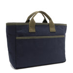 Back angle of the Emery Nodu Nadu tote bag in classic navy blue with moss green trim and dual straps. An open slip compartment in the back allows you to store items like your keys, journal, and more for convenient access. Rectangular silhouette for a classic, timeless feel. 