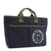 With sleek trim details and a feel-good message, this everyday tote is here to remind you that yes, today (and every day) is a good one. Designed for both style and function, it features plenty of compartments like 2 front slip pockets. Front angle pictured in classic navy blue with moss green trim and straps. White smiley face adorns the front with a cute little flower on its smile in this rectangular silhouette. 