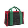 Back angle view of the Nodu Nadu small canvas Marley tote Bag in black. Accented with forest green straps and a bold red trim, this canvas features a subtle metallic shimmer that hits the light whenever you walk for a head-turning detail. 