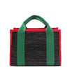 Back view of the Nodu Nadu small canvas Marley tote Bag in black. Accented with forest green straps and a bold red trim, this canvas features a subtle metallic shimmer that hits the light whenever you walk for a head-turning detail. 