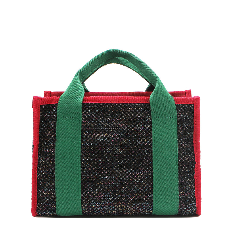 Back view of the Nodu Nadu small canvas Marley tote Bag in black. Accented with forest green straps and a bold red trim, this canvas features a subtle metallic shimmer that hits the light whenever you walk for a head-turning detail. 