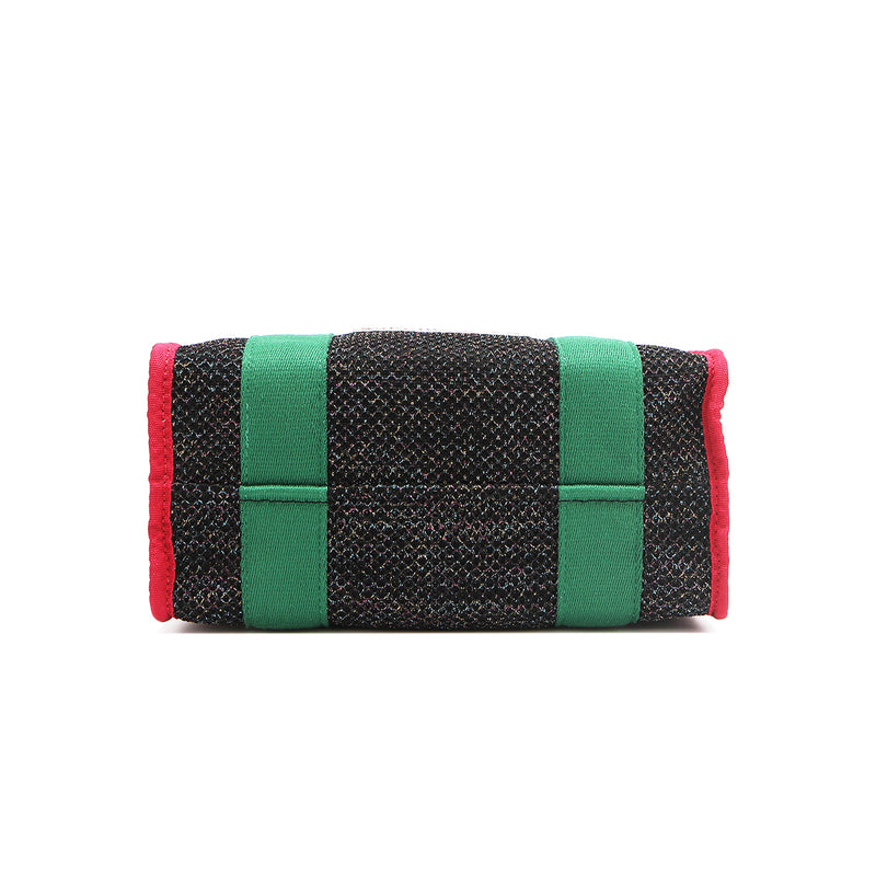 Structured, rectangular base of the Nodu Nadu Marley Bag in Black with grass green strap accents and bold red trim. 