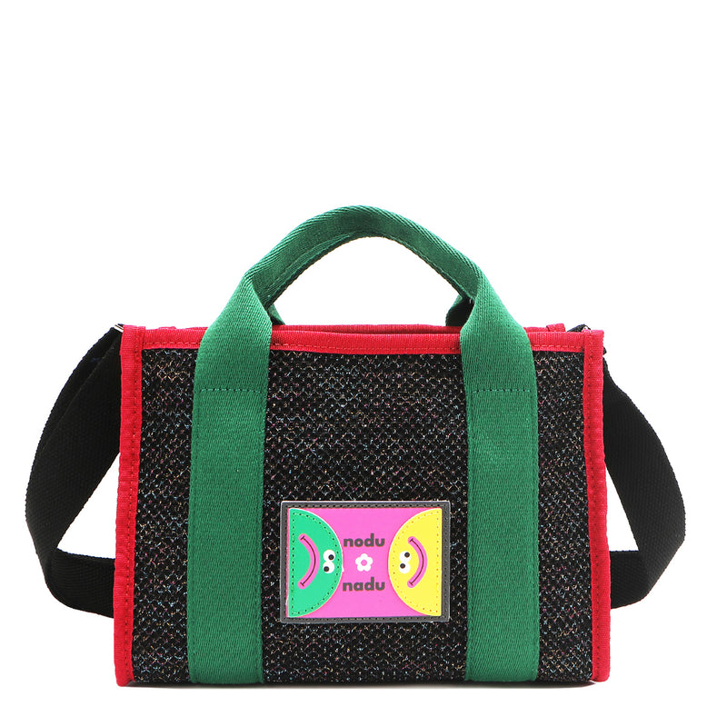 Front view of Nodu Nadu Marley Bag in black with optional, adjustable and detachable black wide shoulder strap attached to show varied carrying options. Wear this rectangular tote by the top handles or around the shoulder or across the body!