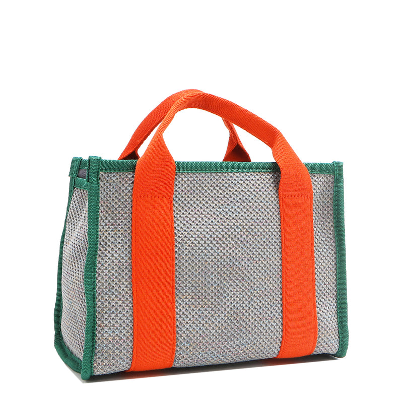 Back angle view of the Nodu Nadu small canvas Marley tote Bag in gray. Accented with bold orange straps and a forest green trim, this canvas features a subtle metallic shimmer that hits the light whenever you walk for a head-turning detail. 