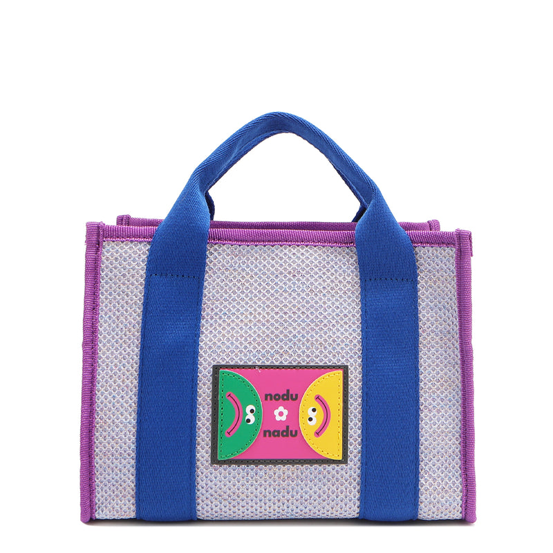 With its effortless slouchy silhouette and striking color-block trim, the Nodu Nadu small Marley tote in Lavender is anything but ordinary. The real showstopper? Its canvas fabric, woven with rainbow metallic stitching that catches the light just right—adding a dreamy shimmer and a touch of everyday magic to your look!