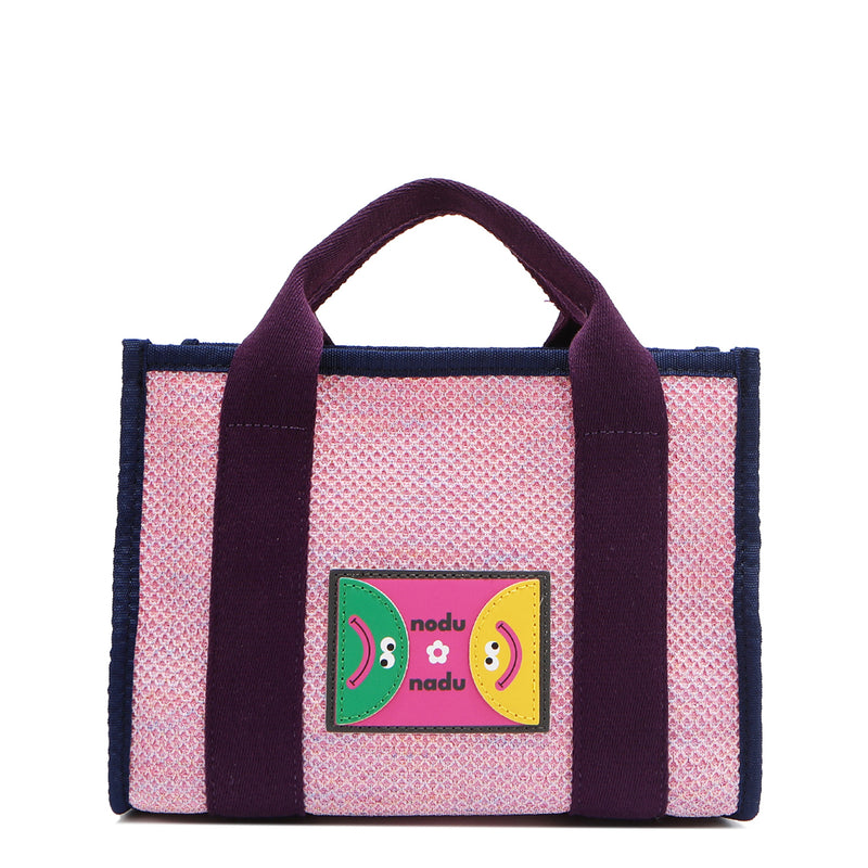 With its effortless slouchy silhouette and striking color-block trim, the Nodu Nadu small Marley tote in Pink is anything but ordinary. The real showstopper? Its canvas fabric, woven with rainbow metallic stitching that catches the light just right—adding a dreamy shimmer and a touch of everyday magic to your look!