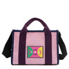 Front view of Nodu Nadu Marley Bag in Pink with optional, adjustable and detachable black wide shoulder strap attached to show varied carrying options. Wear this rectangular tote by the top handles or around the shoulder or across the body!