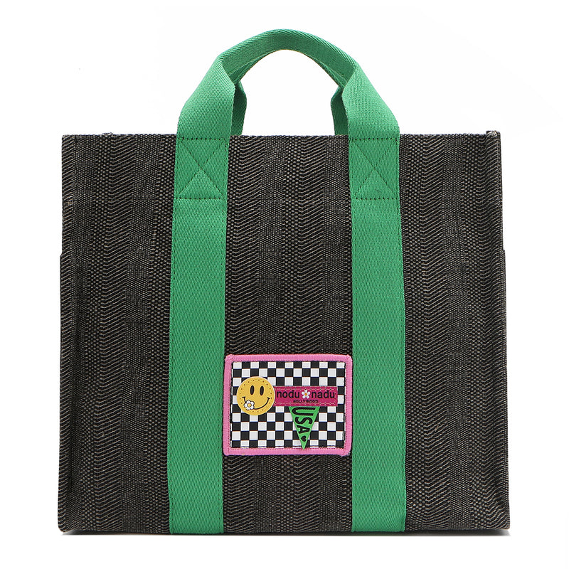 Your must-have carryall for school, weekends, and everything in between! Designed with a soft, relaxed silhouette, the Nodu Nadu Sawyer in Black offers plenty of space to keep notebooks and loose essentials effortlessly organized—so you're always ready to grab and go! Charcoal Black canvas paired with grass green strap accents. 