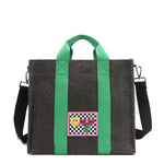 Nodu Nadu Sawyer Bag in Black with grass green strap accents and paired with an adjustable, optional black wide shoulder strap. Wear this bag by the top handles or across the body thanks to the versatile shoulder strap options. 