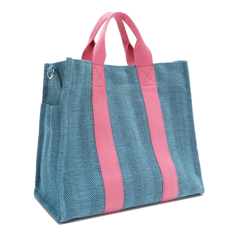 Back angle view of the Nodu Nadu Sawyer Bag in blue showcasing the side D-rings which allow you to attach the optional and adjustable shoulder strap to wear this bag across the body or around the shoulder, perfect for long-term wear and comfort. Side angle also shows the side slip pocket for a convenient touch.