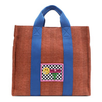 Your must-have carryall for school, weekends, and everything in between! Designed with a soft, relaxed silhouette, the Nodu Nadu Sawyer in Orange offers plenty of space to keep notebooks and loose essentials effortlessly organized—so you're always ready to grab and go! Burnt orange/sienna brown-colored canvas paired with bold blue strap accents. 
