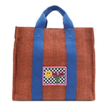 Your must-have carryall for school, weekends, and everything in between! Designed with a soft, relaxed silhouette, the Nodu Nadu Sawyer in Orange offers plenty of space to keep notebooks and loose essentials effortlessly organized—so you're always ready to grab and go! Burnt orange/sienna brown-colored canvas paired with bold blue strap accents. 