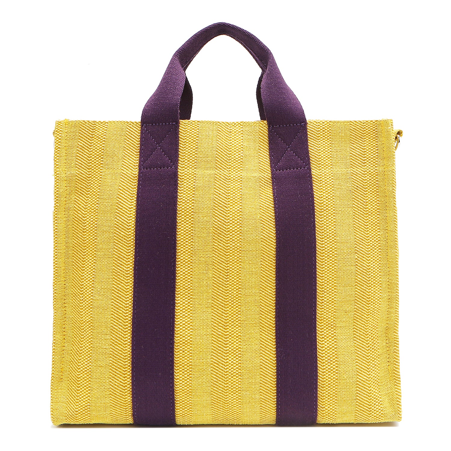 Back view of the Nodu Nadu Sawyer Bag in Yellow with eggplant purple strap accents. Durable, canvas material in a rectangular silhouette offers endless expression to mix and match your style no matter the season or occasion. 