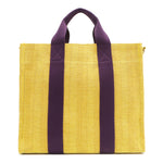 Back view of the Nodu Nadu Sawyer Bag in Yellow with eggplant purple strap accents. Durable, canvas material in a rectangular silhouette offers endless expression to mix and match your style no matter the season or occasion. 