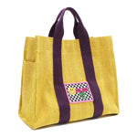 Front angle view of the Nodu Nadu Sawyer Bag in Yellow. Crafted in durable canvas with side D-rings for optional shoulder strap attachment so you can wear this bag as a handbag, shoulder bag, or crossbody! It also features side slip pockets for a convenient touch. 