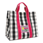 Angled front view of the Nodu Nadu Canvas Blair Bag in Black – highlighting pink handles, side panel with open slip pocket, and checkered embroidered patch with smiley face and nodu nadu stitch logo.