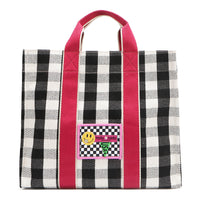 Nodu Nadu Canvas Blair Bag in Black – Stylish black and white checkered tote with bold pink handles, featuring a playful front patch design and durable canvas construction, perfect for everyday use or casual outings.