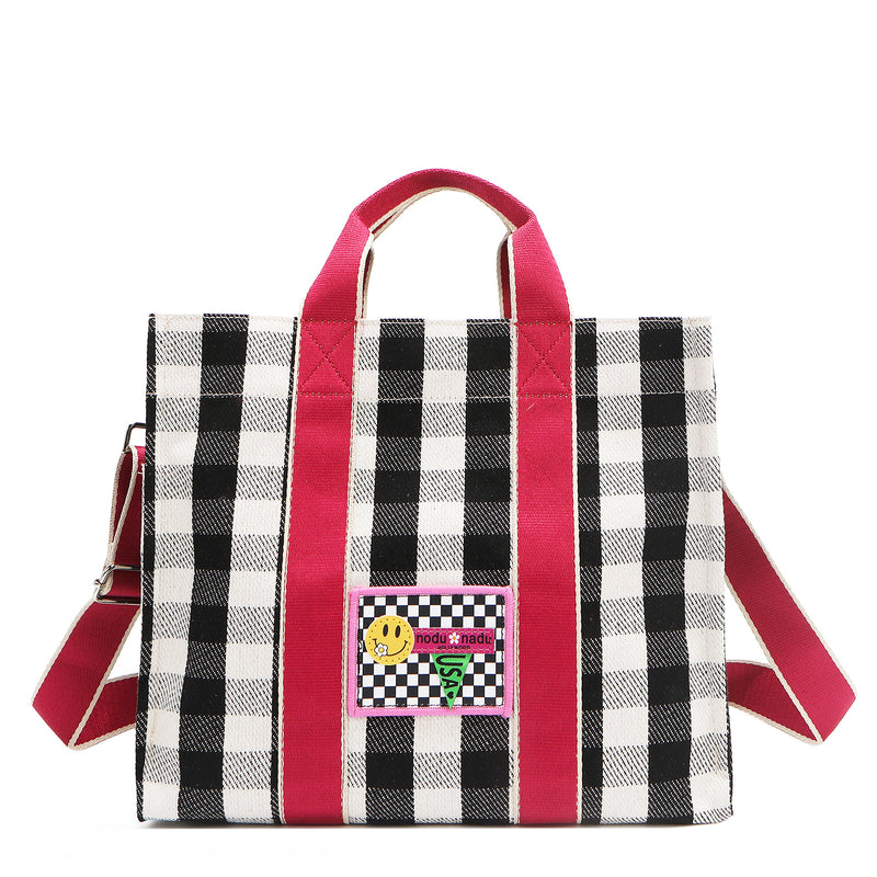 Nodu Nadu Blair Bag in Black – frontal shot showcasing vibrant pink top handles and retro check pattern. Pictured with optional, adjustable matching pink shoulder strap with white trim. 