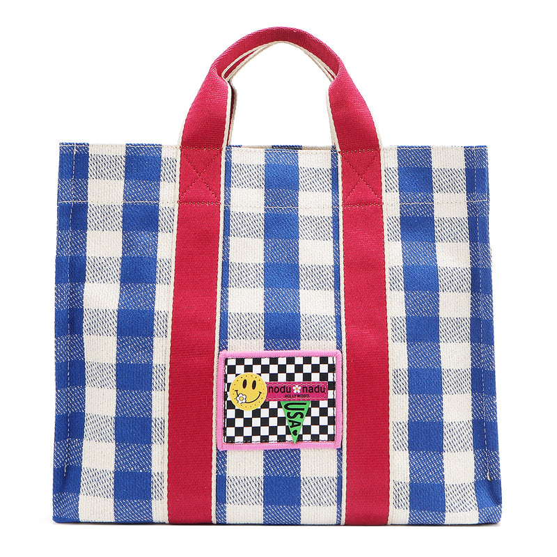 Blue and white checkered Nodu Nadu Blair Bag front – features hot pink straps and a retro-inspired logo stitched patch with checker print and smiley face. 