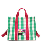 Green and white checkered Nodu Nadu Blair Bag front adorned with a checker print stitched logo with Nodu Nadu smiley face. Grass green paired with classic white and accented with pops of hot pink. Pictured with its adjustable, detachable tonal hot pink shoulder strap to showcase varied carrying options and versatility when styling and wearing.