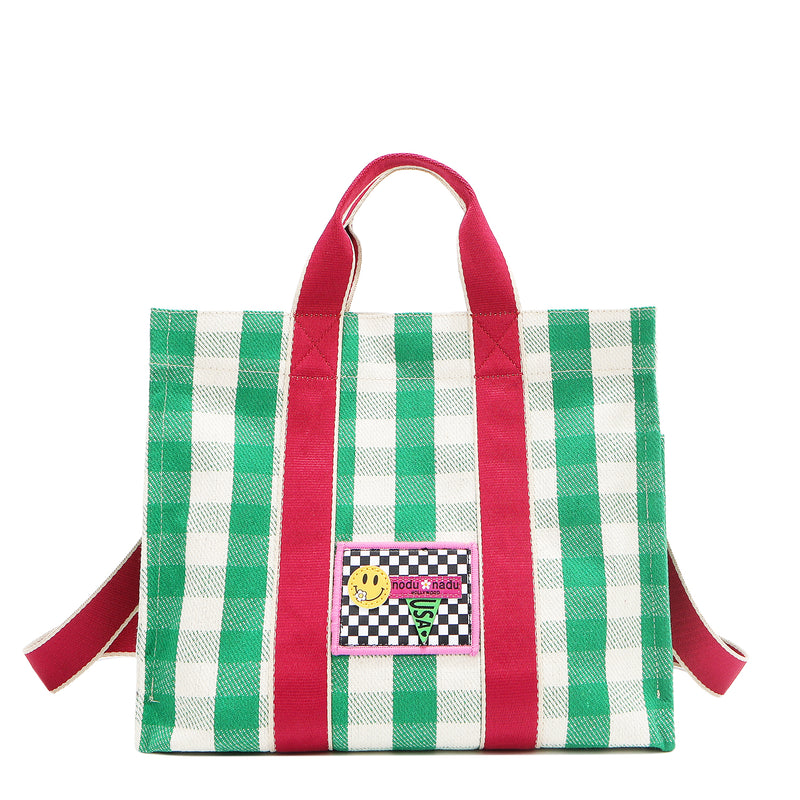 Green and white checkered Nodu Nadu Blair Bag front adorned with a checker print stitched logo with Nodu Nadu smiley face. Grass green paired with classic white and accented with pops of hot pink. Pictured with its adjustable, detachable tonal hot pink shoulder strap to showcase varied carrying options and versatility when styling and wearing.