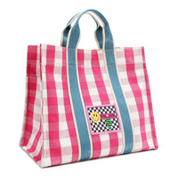 Front angle of the Nodu Nadu Blair Canvas Bag in pink. Made of durable canvas and designed in Los Angeles, California. Bold pink and white gingham print paired with sky blue straps make for a sweet and feminine look! Rectangular silhouette for a timeless finish.