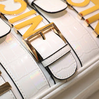 Close-up macro shot detail of the Nicole Lee Calista handbag styles in white with an iridescent finish on the strap details. 