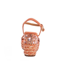 The platform wedge is adorned with pink rhinestones and  braid detailing.