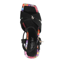 THE SANDAL FROM A VIEW FROM ABOVE. THE CRISSCROSS STRAPS WITH THE NL INITIALS IN THE MIDDLE. THE BLACK INSOLE WITH FLORAL PRINT ON THE EDGES.
