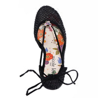 MAYA WRAP ESPADRILLE WEDGE SANDAL FROM A VIEW FROM ABOVE. FEATURES RHINESTONE MESH TOE CAP. TWO STRAPS THAT ARE TIED IN A BOW SHAPE.  THE INSOLE HAS A FLORAL PRINT.